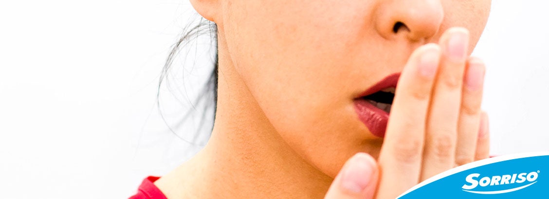 mulher conferindo como acabar com o mau hálito